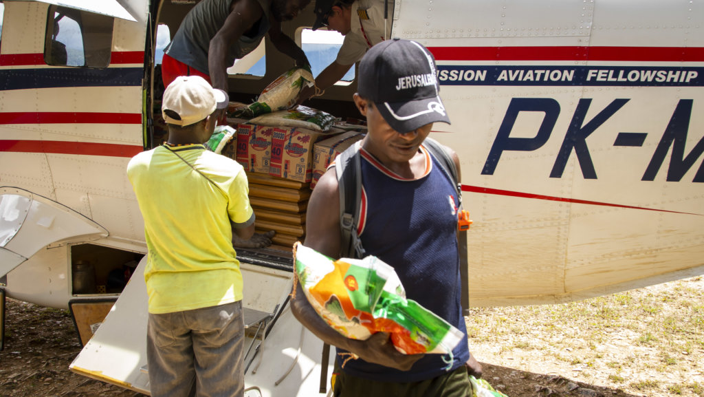 Food and supplies arrives in a remote village in Papua, Indonesia by Mission Aviation Fellowship aircraft 